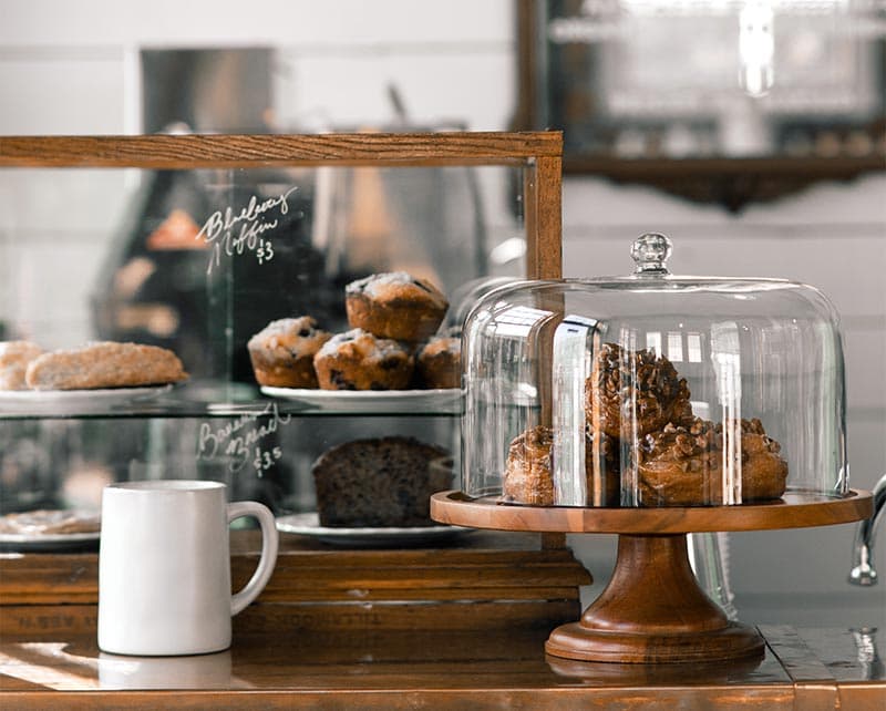 Pastry case and mugs by the counter